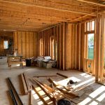 Sunlit interior with wood framing, showcasing home construction progress.