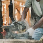 Action shot of a carpenter using a circular saw outdoors, demonstrating precise craftsmanship.